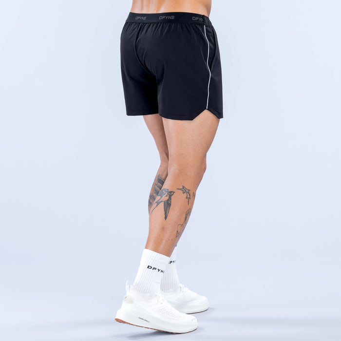 Men's black 4-inch training shorts, back view, elastic waistband and side piping