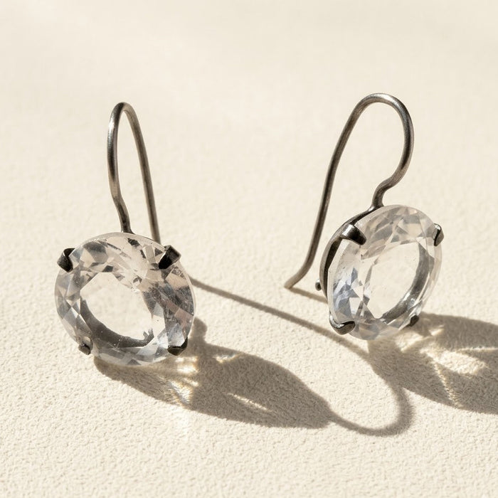 Silver-tone drop earrings with round faceted clear stone in prong setting