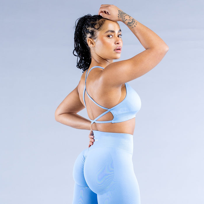 Light blue backless sports bra with strappy open back and supportive cups