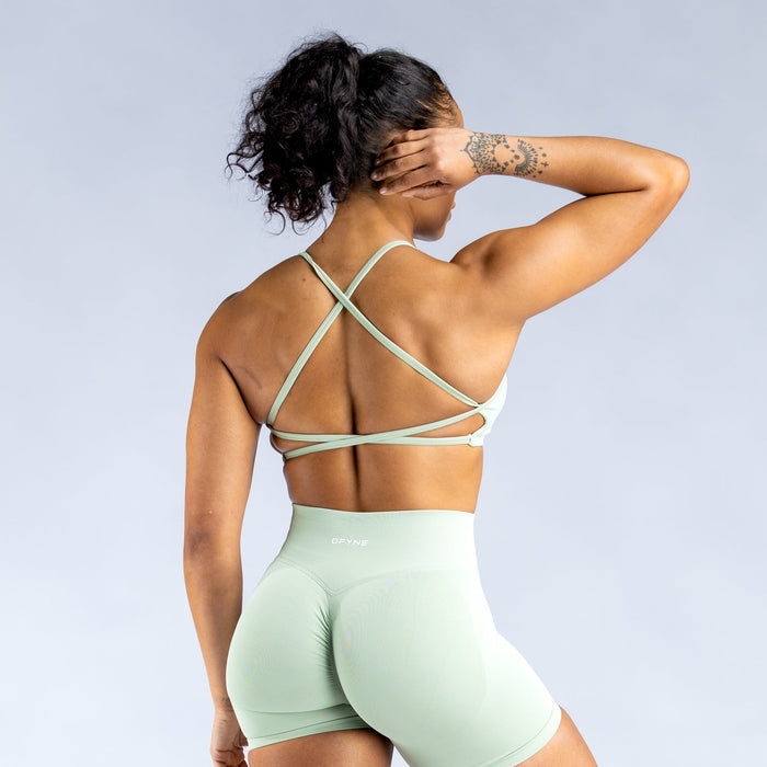 Mint green backless sports bra from behind, crisscross open-back straps