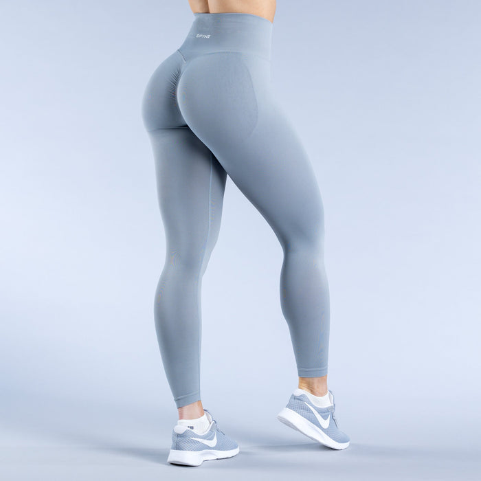 Sky-blue leggings, back three-quarter view with sculpting seam lines