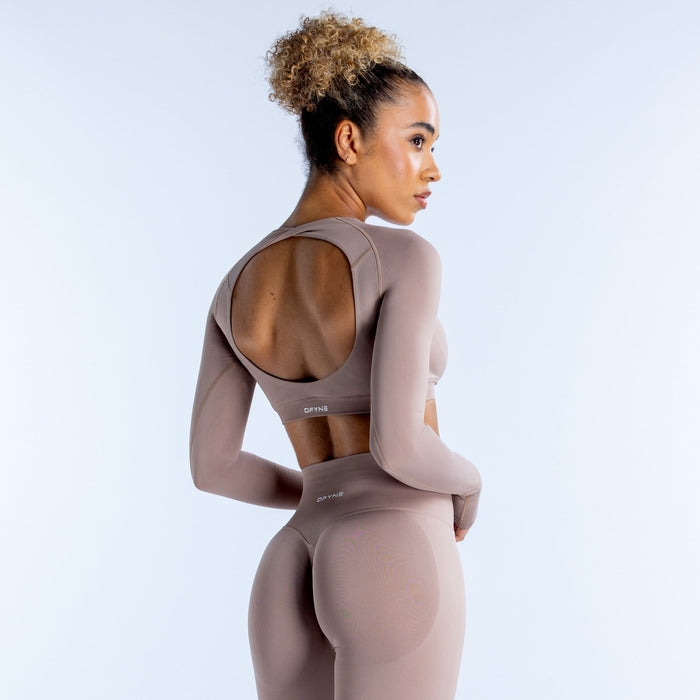 Taupe long-sleeve crop top with scooped back and fitted stretch fit.