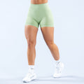 Mint green fitted athletic shorts with waistband, side view on model
