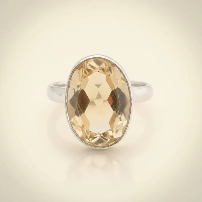 Ring with a large faceted yellow gemstone on a white background