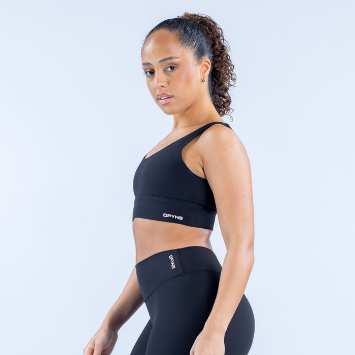 Black sports bra with racerback straps and small logo patch on chest