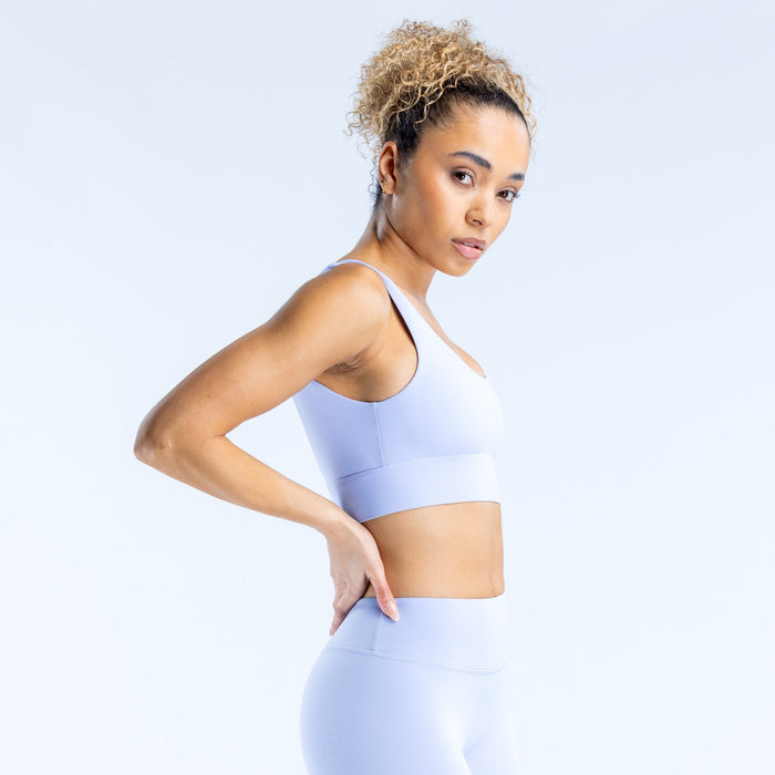 Light blue sports bra with racerback straps and wide back neckline, side pose