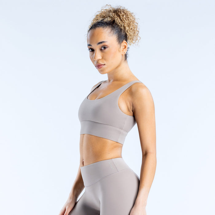 Light gray sports bra side view with smooth fabric and racerback straps