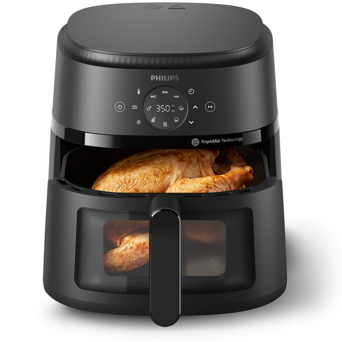 Black Philips air fryer with a cooked chicken inside on a white background