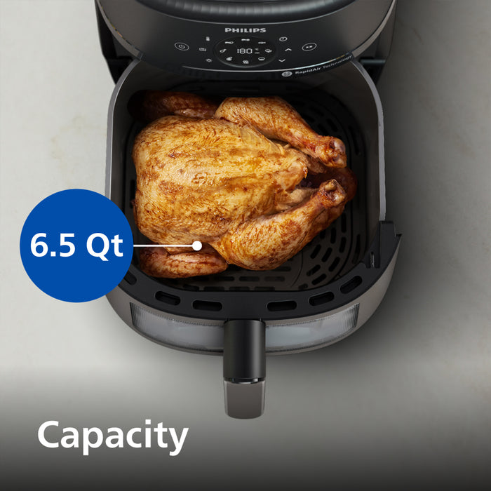 Philips air fryer with a roasted chicken inside, labeled with 6.5 Qt capacity.
