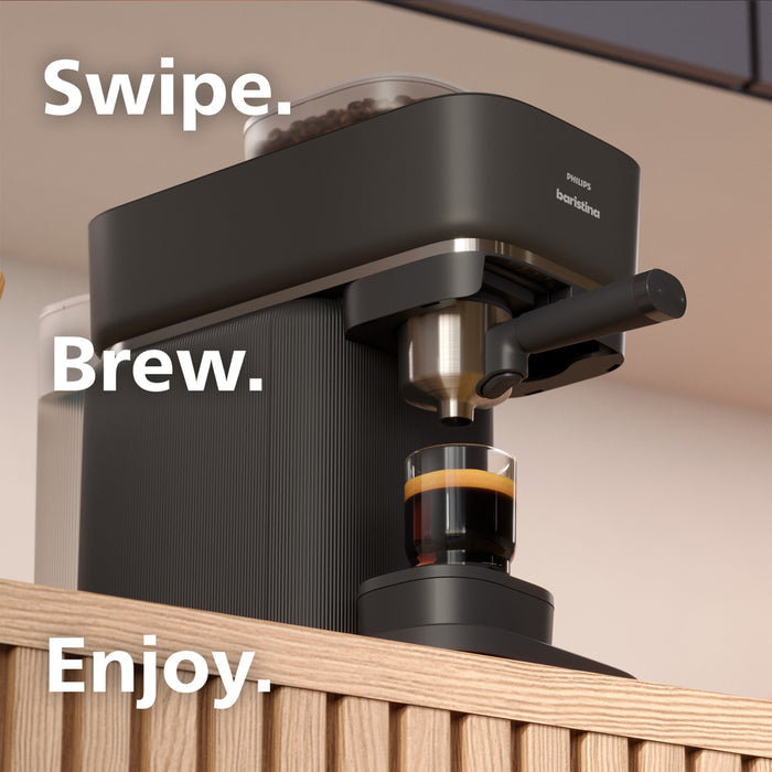 Black coffee machine with a glass of coffee on a wooden surface, featuring the text 'Swipe. Brew. Enjoy.'