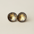 Pair of round earrings with gold and black design on a white background