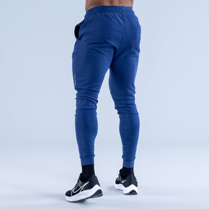 Blue tapered jogger pants, elastic waist and cuffed ankles, rear view
