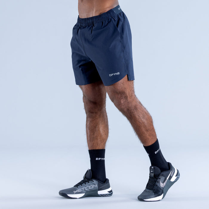 Navy training shorts with elastic waistband and side pocket, logo on hem