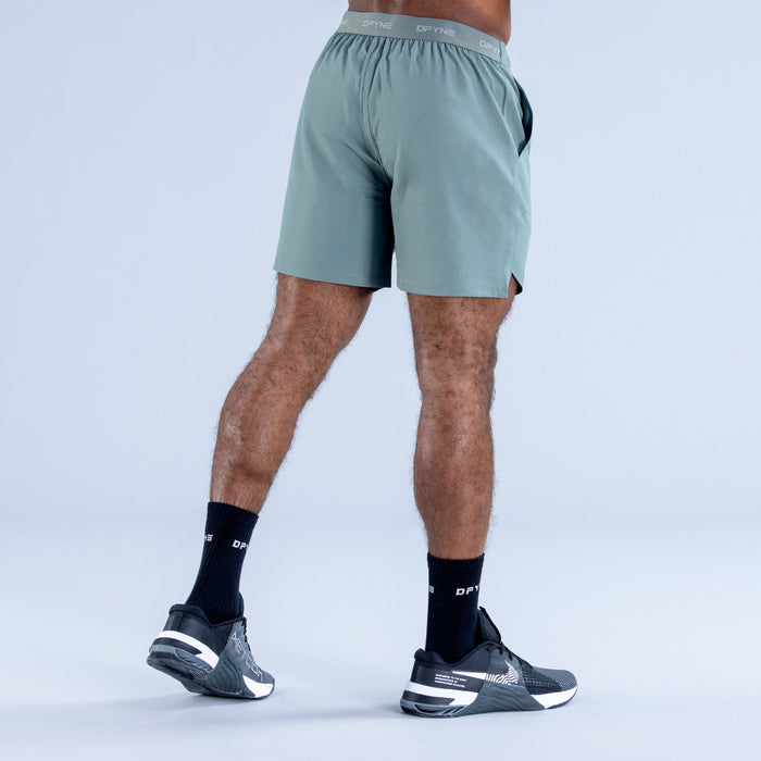 Teal training shorts with elastic waistband and side seam detail, back view