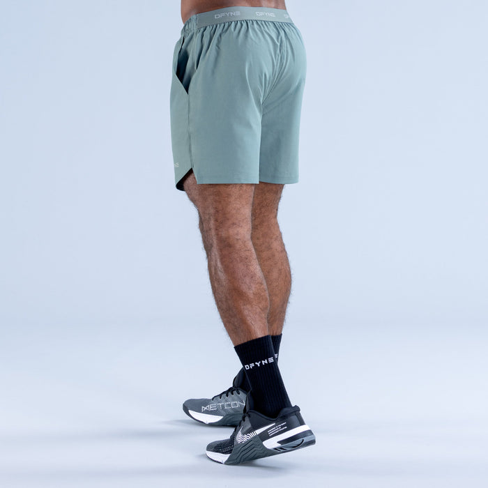 Teal training shorts, side view with elastic waistband and leg-length hem