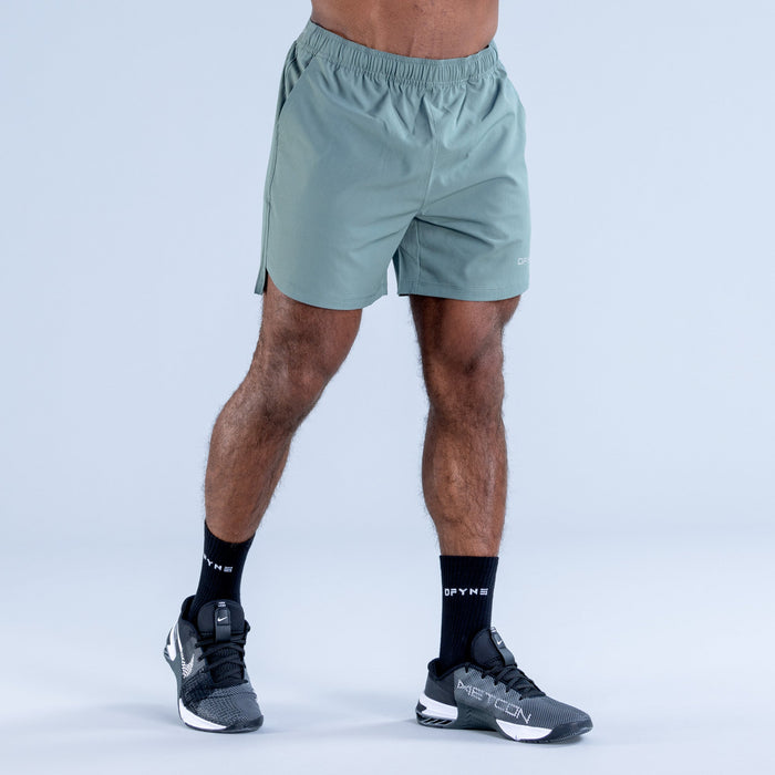 Teal training shorts with elastic waistband and small side logo detail