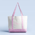 White canvas tote bag with lavender handles and bottom trim, cursive logo on front
