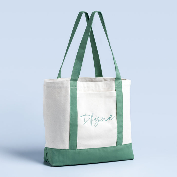 Canvas tote bag, white body with green shoulder straps and bottom, front logo print